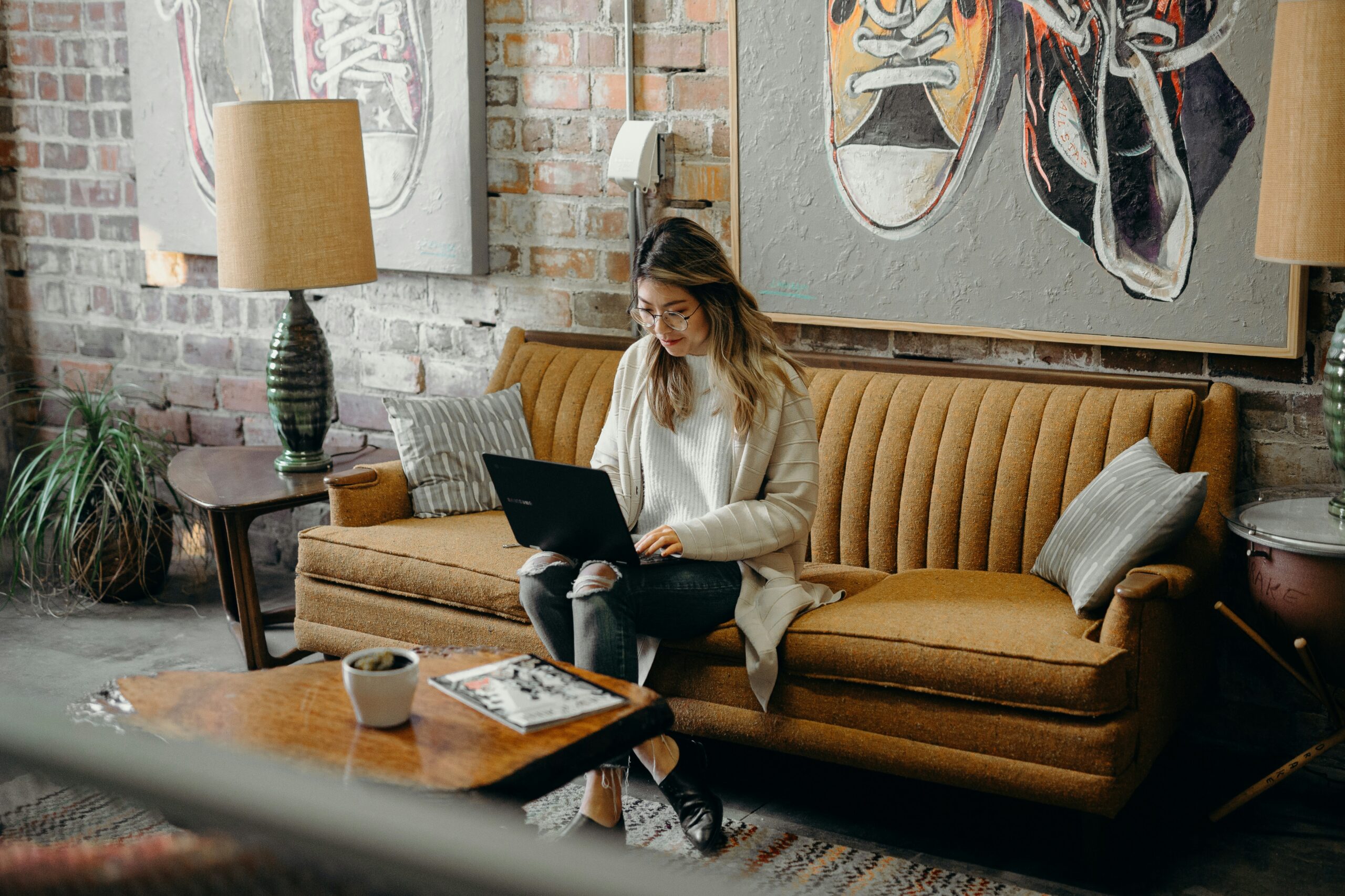 Woman sitting in a loft working from her laptop